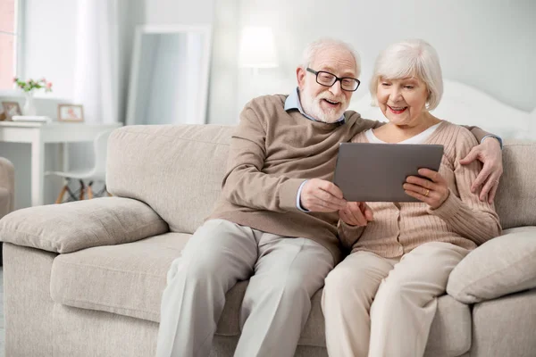 Gente anziana gioiosa che guarda lo schermo del tablet — Foto Stock