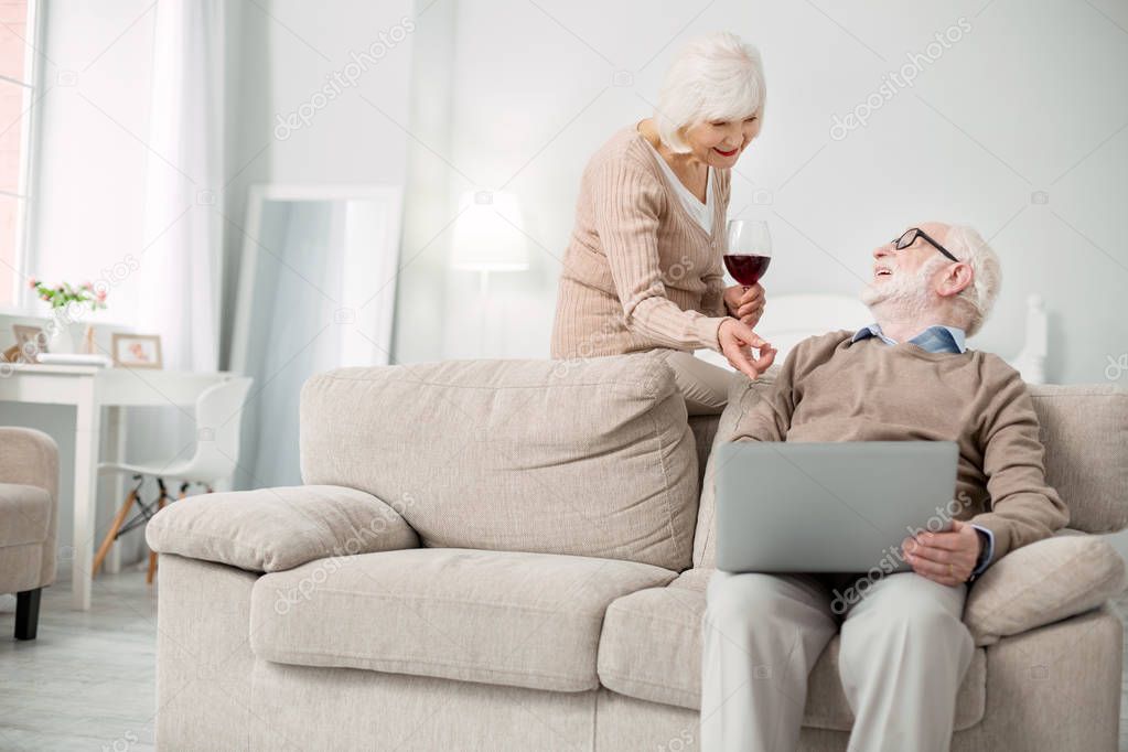 Delighted senior woman pointing at the laptop screen