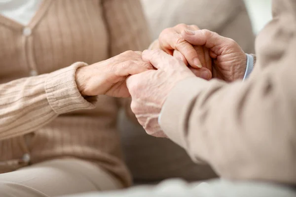 Nice aged man holding hands of his wife