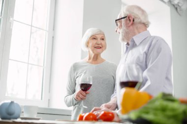 Bir bardak şarap tutan pozitif rahat kadın