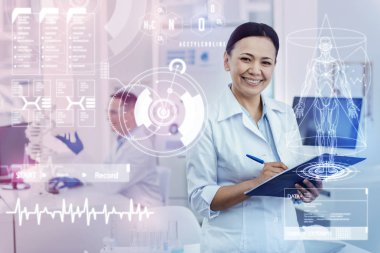Notlar yaparken gülümseyen pozitif doktor