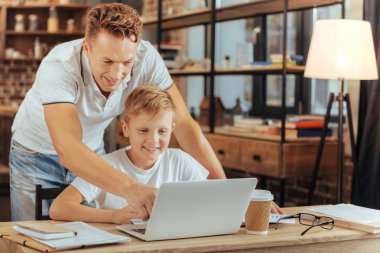 Dizüstü bilgisayar ekranında işaret eden güzel pozitif adam