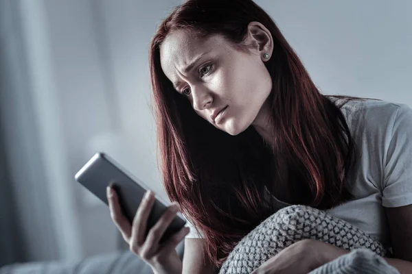 Bleak depressed woman updating messages — Stock Photo, Image