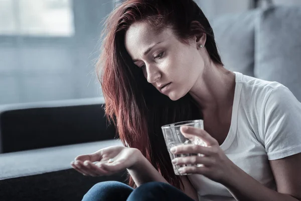 Депрессивная грустная женщина принимает таблетки — стоковое фото
