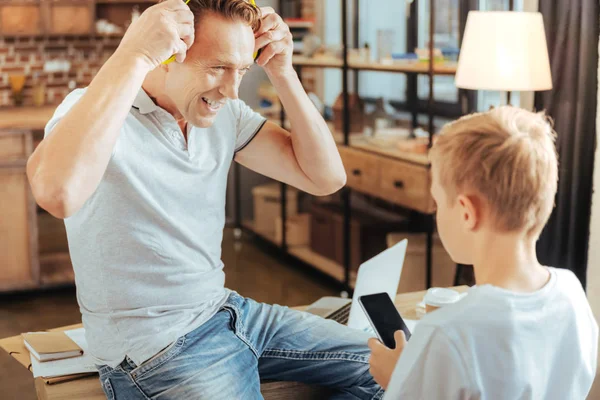 Hombre guapo positivo poniéndose auriculares — Foto de Stock