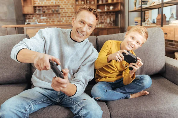 Feliz pai e filho encantados jogando videogames — Fotografia de Stock