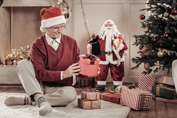 Joyful äldre man undersöker presentbox — Stockfoto
