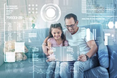 Sevgi dolu baba kızını sarılma ve modern bir dizüstü bilgisayar holding