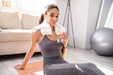 Sevimli kadın egzersiz yaptıktan sonra bir bardak su ile poz