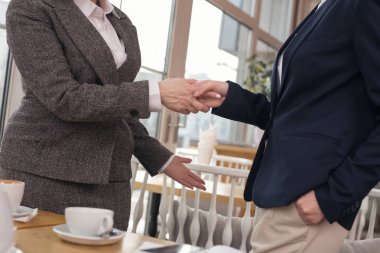 Bir sözleşme imzalamadan sonra el sıkışan kararlı iş kadınları