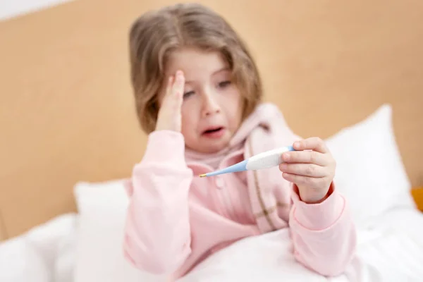 Sjukt barn hålla en termometer — Stockfoto