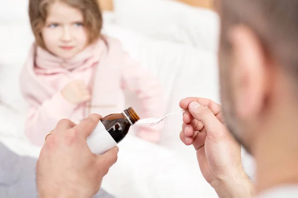 Orolig pappa att ge medicin till hans dotter — Stockfoto