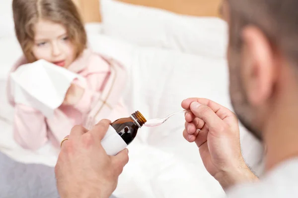 Berörda far att ge medicin till hans dotter — Stockfoto