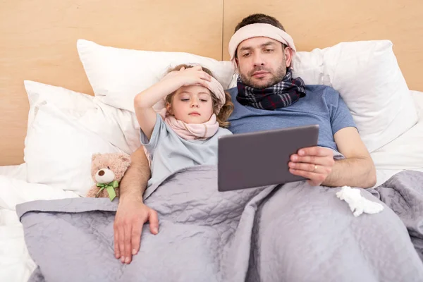 Chica enferma y papá viendo una película —  Fotos de Stock