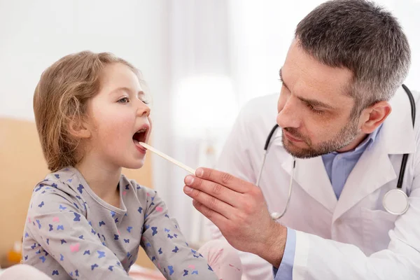 Determinado médico examinando niñas garganta — Foto de Stock