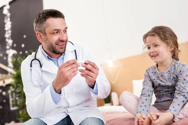 Content doctor looking at a little girl — Stock Photo, Image