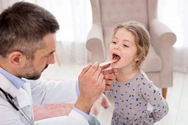 Alvorlig læge undersøger sin patient - Stock-foto