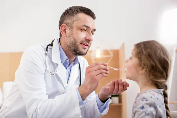 Bom médico dando medicação para uma menina — Fotografia de Stock