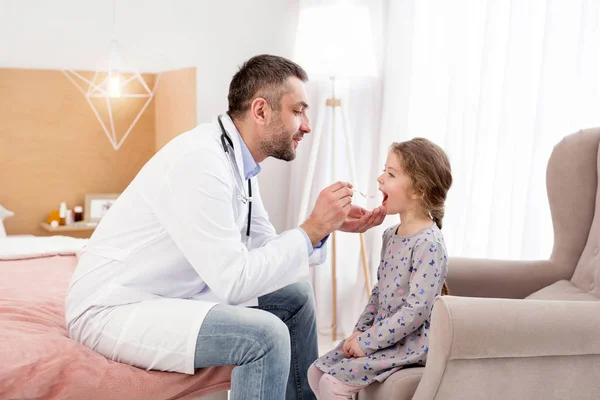 Médico atento dando medicación a una niña — Foto de Stock