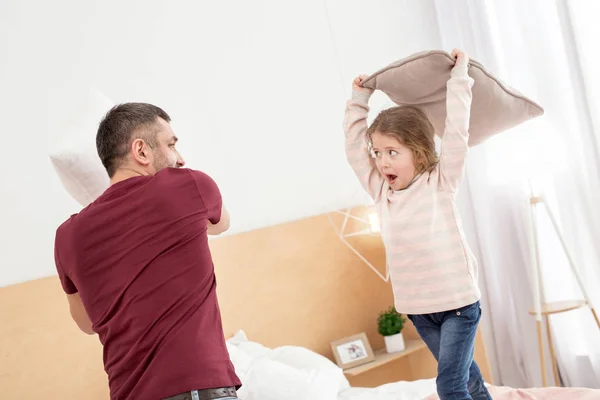 Contenido papá y chica teniendo una batalla de almohadas —  Fotos de Stock