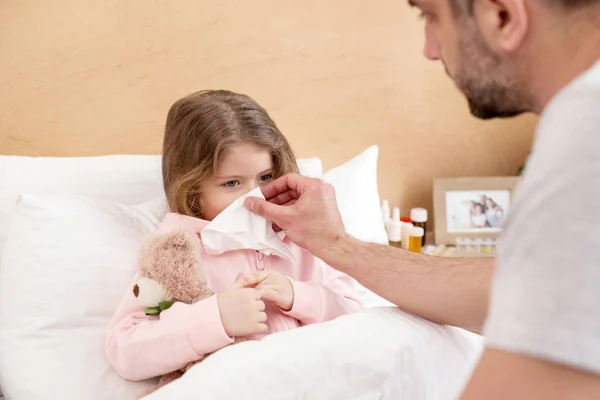Ohälsosamma dotter blåser hennes näsa — Stockfoto