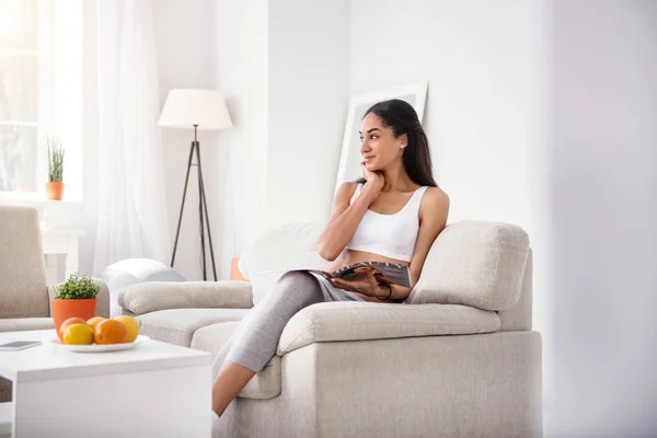 Pretty woman being deep in thought while reading magazine — Stock Photo, Image