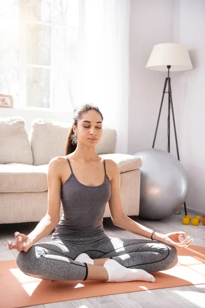 Affascinante giovane donna che pratica yoga a casa — Foto Stock