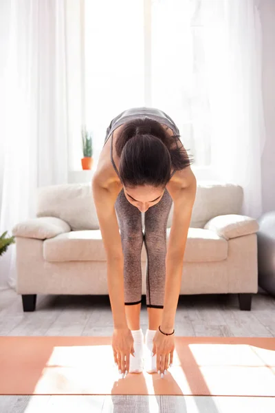 Mulher flexível tocando o chão durante o treino — Fotografia de Stock