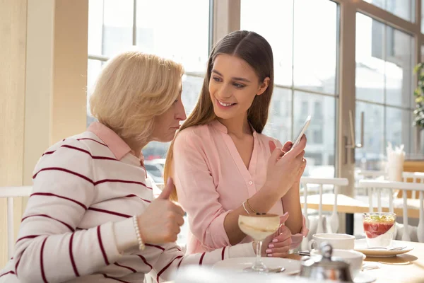 Inspired girl showing photos to her granny — Stock Photo, Image