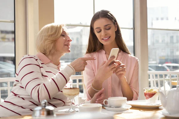 Happy girl showing photos to her granny — Stock Photo, Image