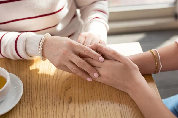 Любляча дівчина тримає руки зі своєю бабусею — стокове фото