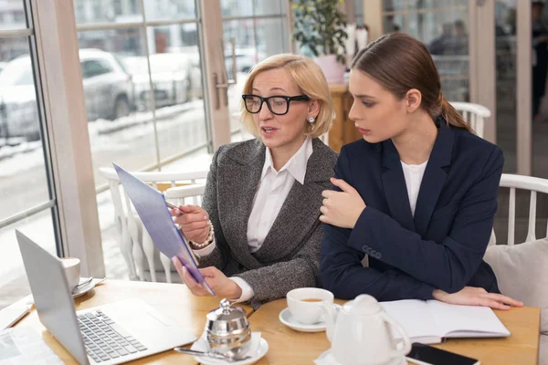 Seriöse Geschäftsfrau diskutiert mit ihrem Partner über Statistiken — Stockfoto