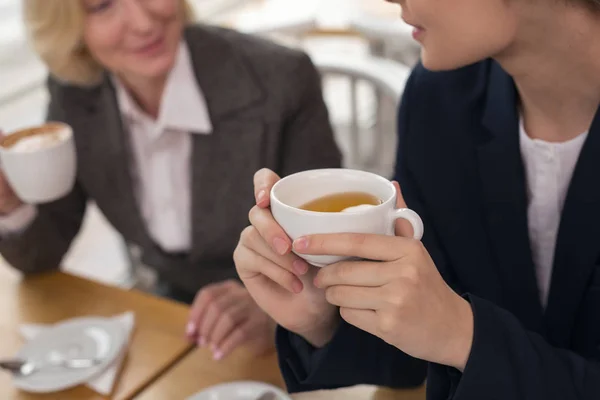 Решительные деловые женщины, пьющие кофе с горячим ароматом — стоковое фото