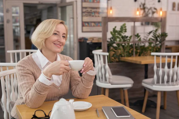 Радостная женщина отдыхает в кафе — стоковое фото