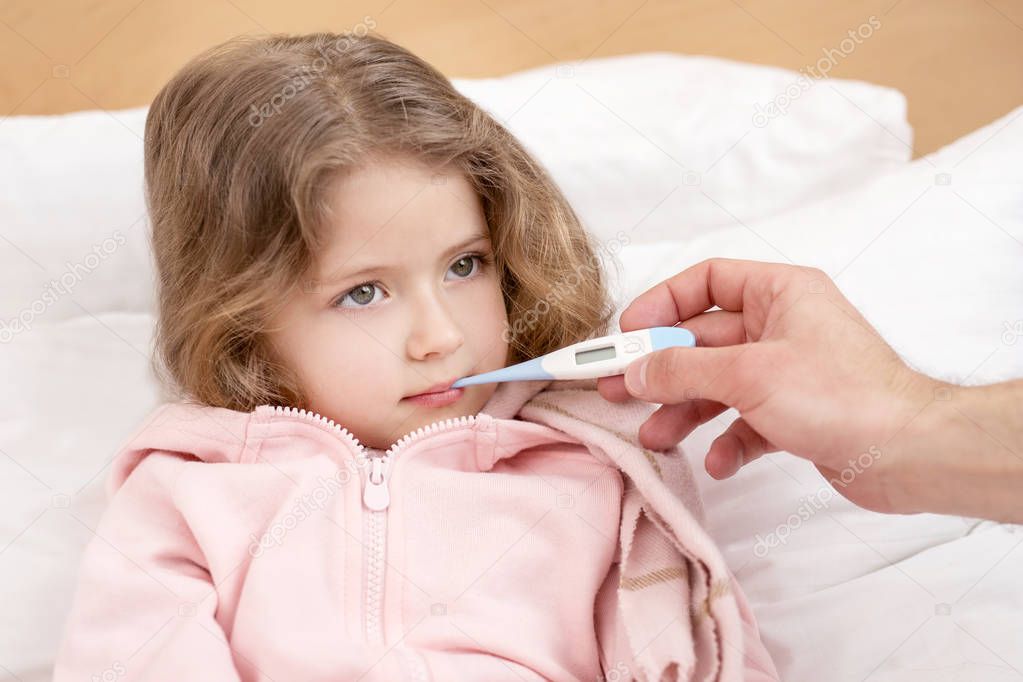 Adorable child having a thermometer in her mouth