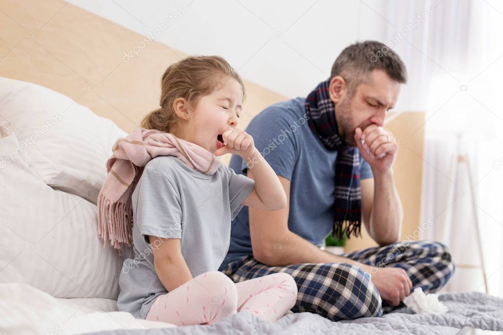 Sick father and daughter coughing 