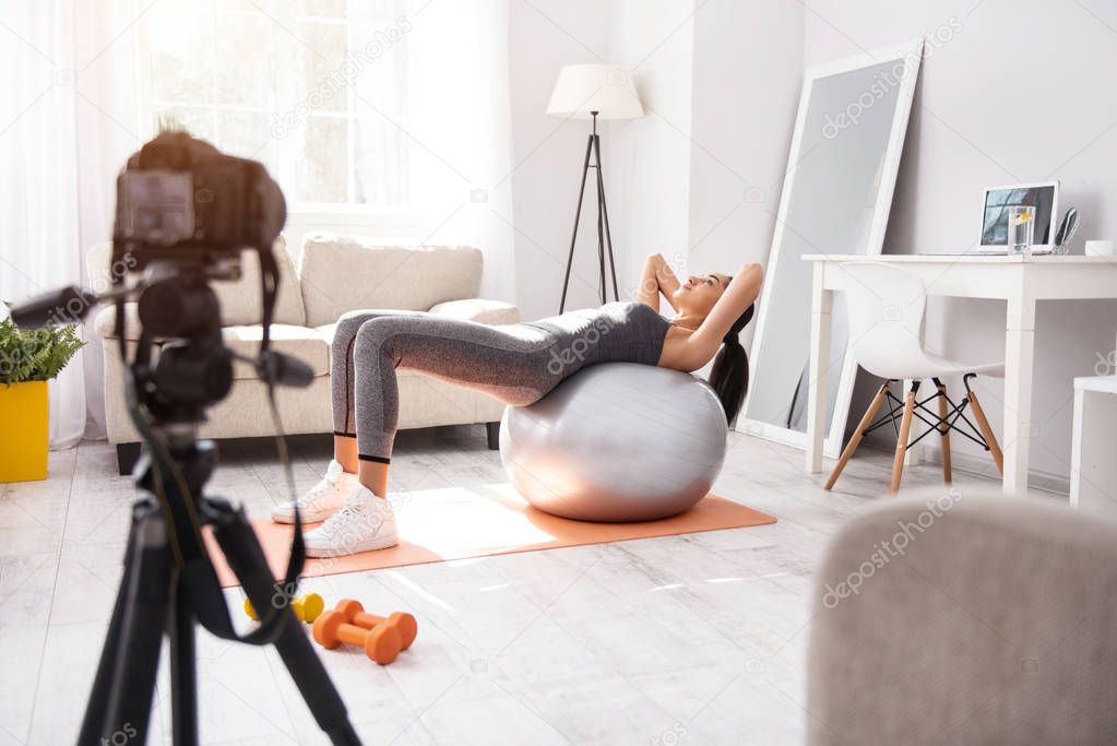 Slim young woman exercising on yoga ball