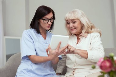 Pozitif yaşlı kadın tablet kullanmaya çalışıyor