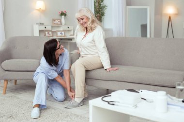 Neşeli hemşire yaşlı kadın terlik almak