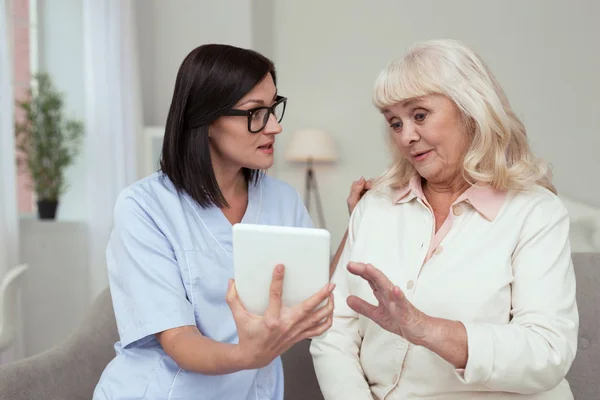 Επικεντρώθηκε νοσοκόμα δείχνει tablet σε γυναίκες μεγαλύτερης ηλικίας — Φωτογραφία Αρχείου