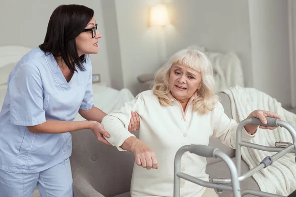 Mooie verpleegster oudere vrouw been opgevend — Stockfoto