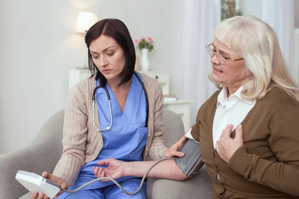 Vérnyomás monitoring szomorú női gondozó — Stock Fotó