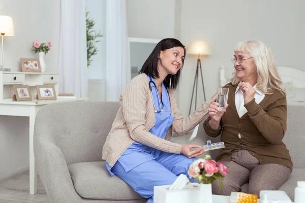 Gelukkig vrolijke verpleegkundige ondersteuning bij het beheren van medicatie — Stockfoto