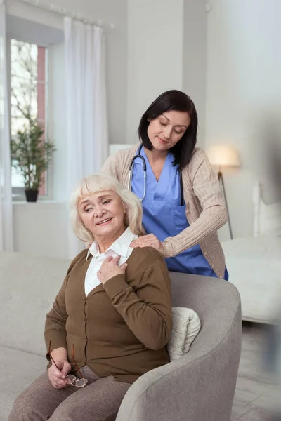 Enfermeira positiva relaxante mulher idosa — Fotografia de Stock