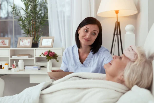 Krankenschwester lindert Schmerzen älterer Frauen — Stockfoto