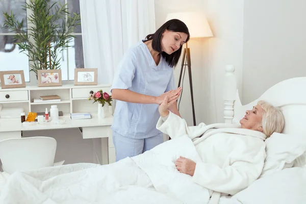 Enfermeira confiante animando a senhora mais velha — Fotografia de Stock