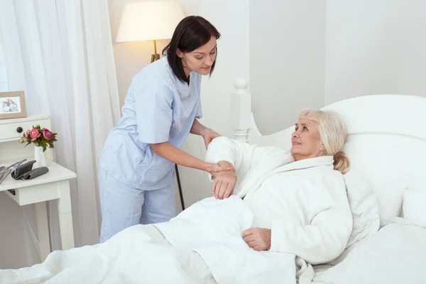 Enfermeira atenciosa reconfortante senhora idosa — Fotografia de Stock