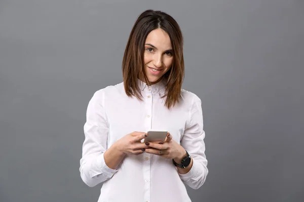 Pozitivní mladá žena pomocí svého smartphonu — Stock fotografie