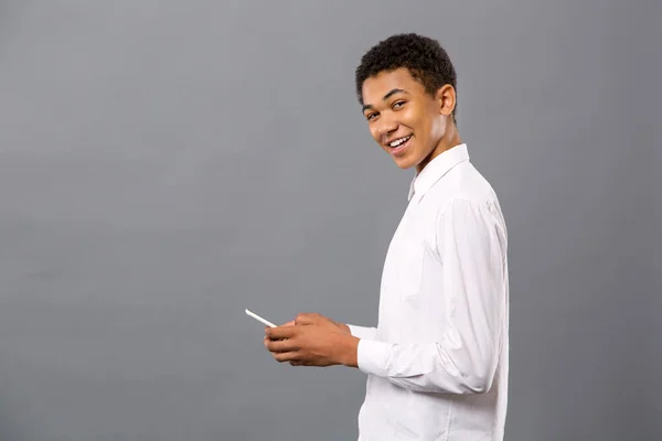 活泼开朗的年轻人用他的智能手机 — 图库照片