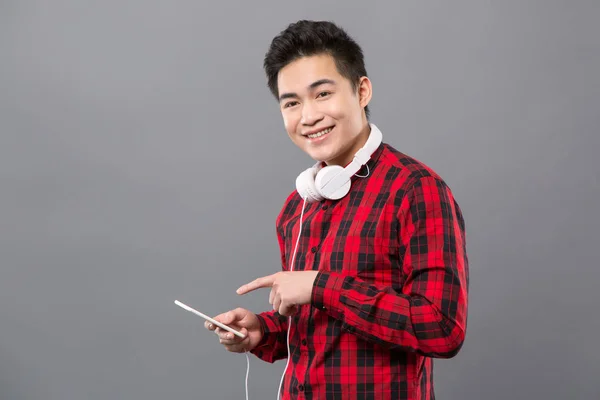 Joven agradable apuntando a su teléfono inteligente — Foto de Stock